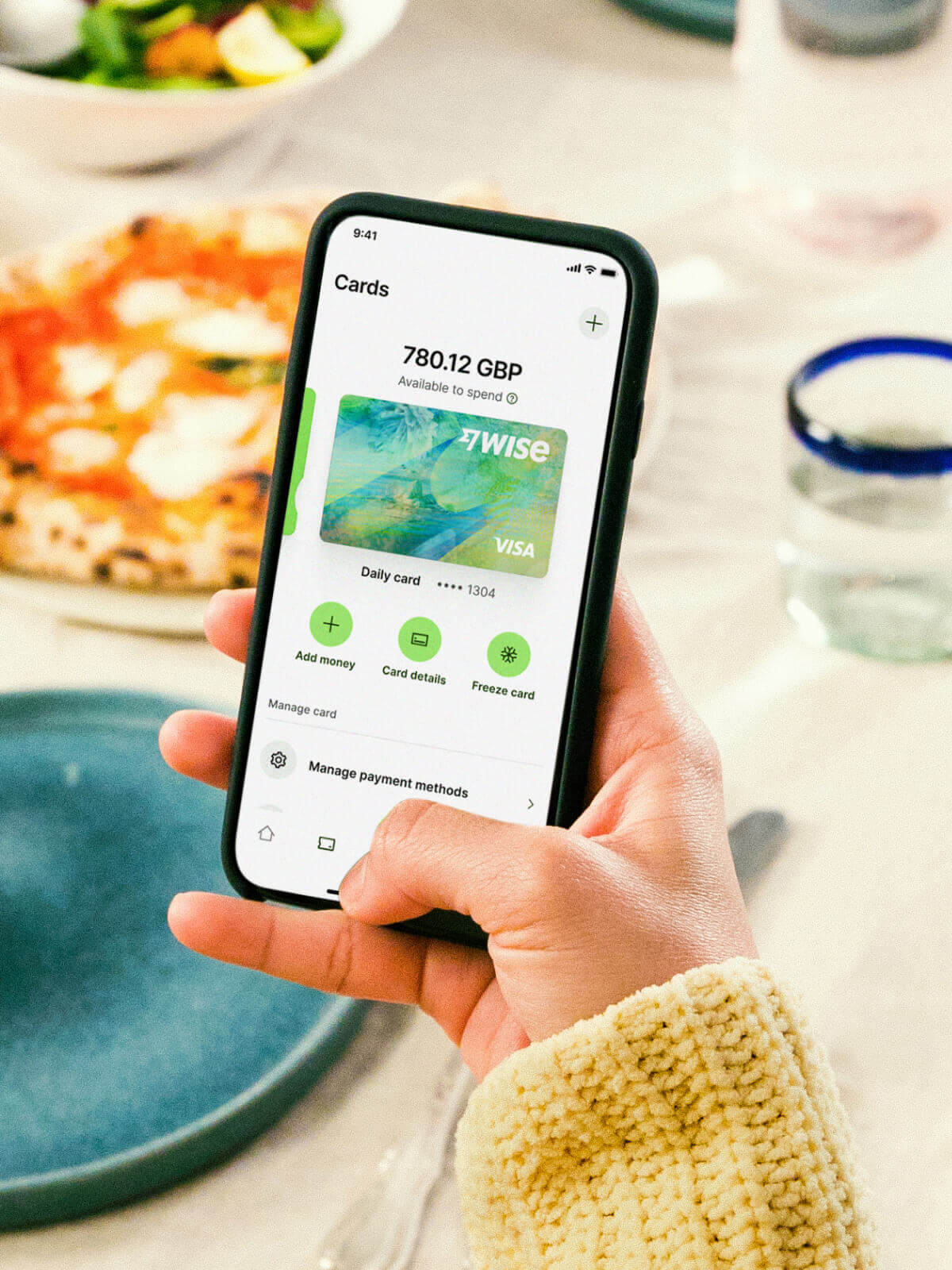 A person holding a phone displaying a digital Wise card